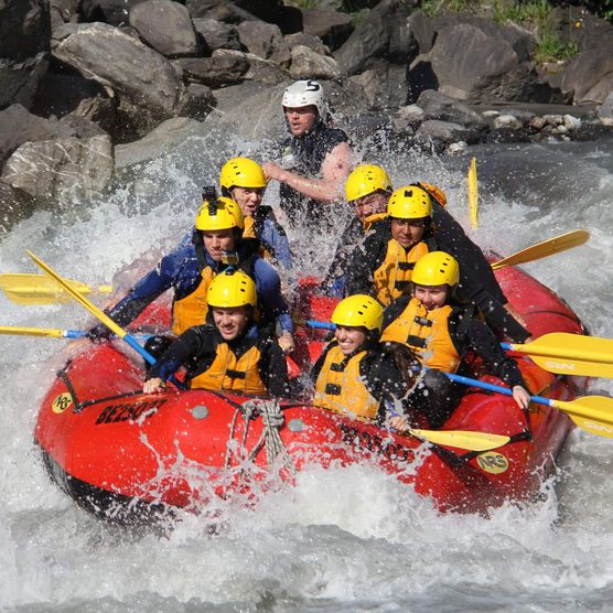 Gruppe in rotem Boot im Wildwasser auf der Lütschine