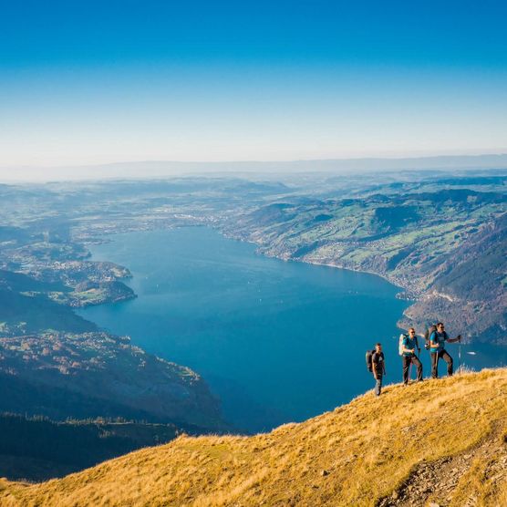 Drei Wanderer auf dem Grat auf dem Weg zum Morgenberghorn und im Hintergrund der Thunersee